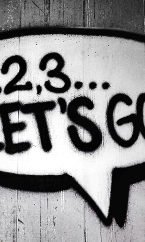 Black and white street art featuring a bold motivational message in a speech bubble.